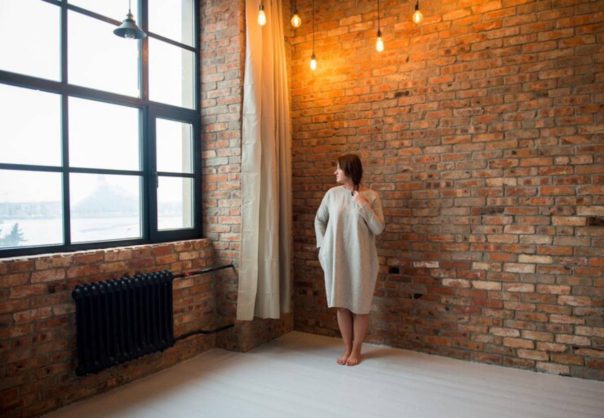 Cozy interior featuring exposed brick walls, large windows, and warm light fixtures, creating a serene and inviting atmosphere.