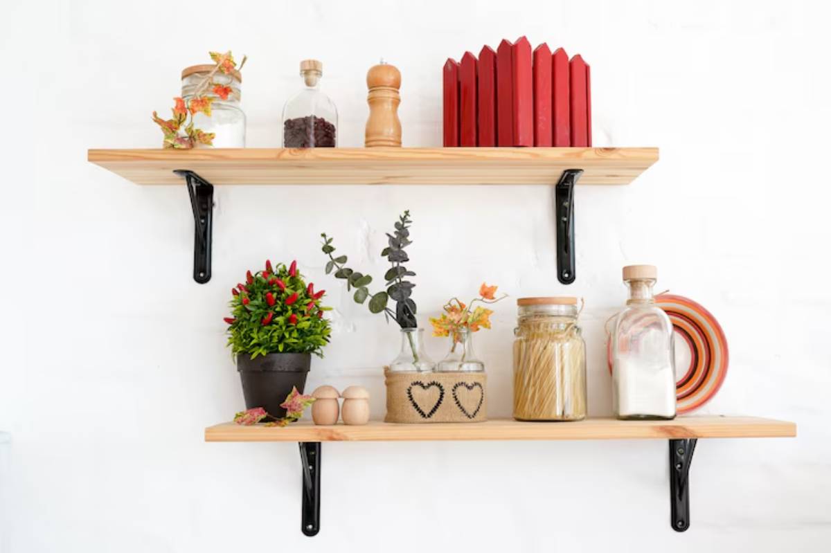 Decorative wooden shelves with plants, jars, and kitchen items, set against a white wall, creating a cozy and stylish ambiance.