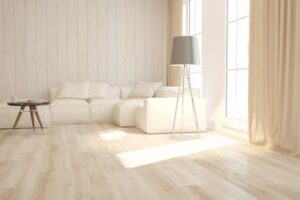 Bright and airy living room featuring a white sectional sofa, a wooden coffee table, and a stylish floor lamp by sunlit windows.